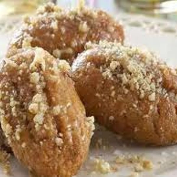 Three golden-brown crumb-coated pastries arranged on a white plate.